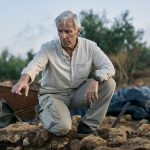 Michael Cosmopoulos points to something in a trench at Iklaina, Greece
