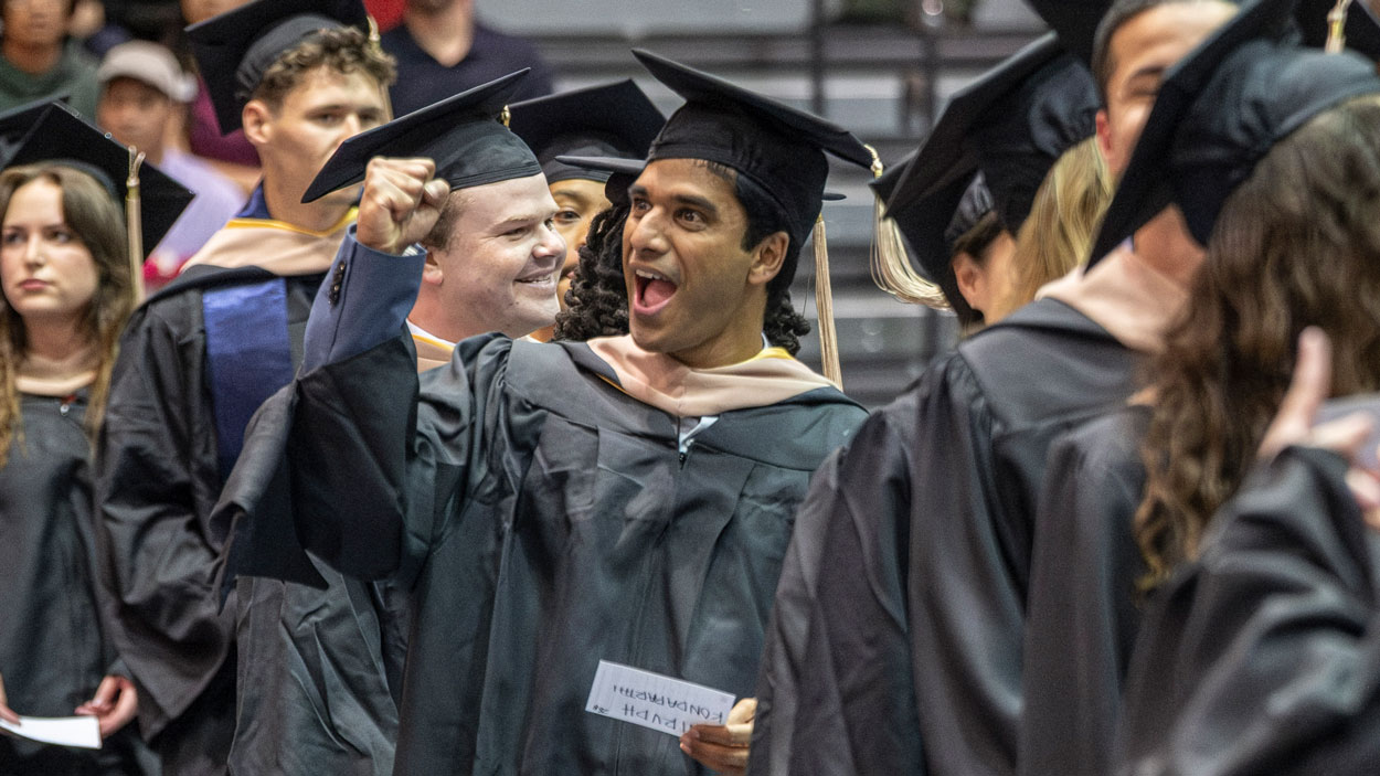 Anirudh Kondaparthi, an MBA graduate, gestures to family and friends during the College of Business commencement ceremony.