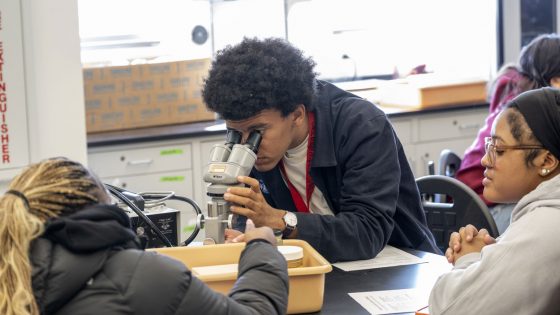 A student looks through a microscope during one of the Bridge Program Saturday Academy's science classes