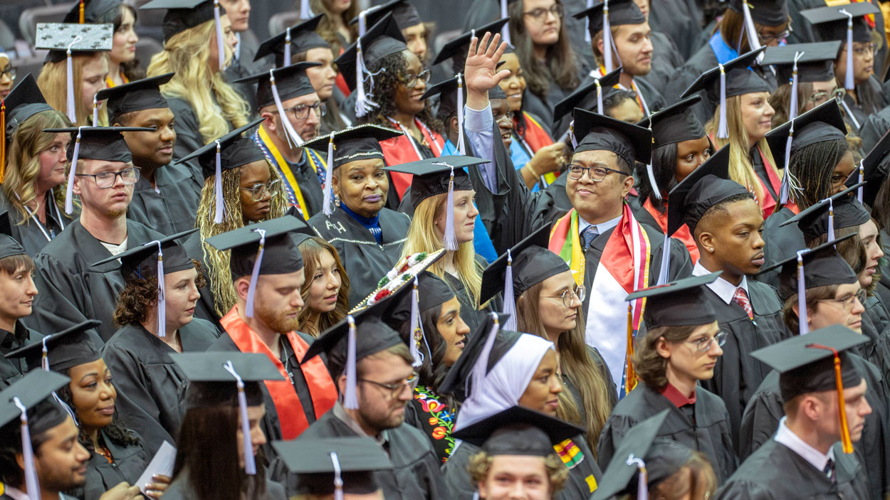 UMSL Bachelor of Science Data Science and Analysis student Sai Kaung Khant waves to family and friends during the fall 2025 commencement ceremony on Saturday December 20, 2025
