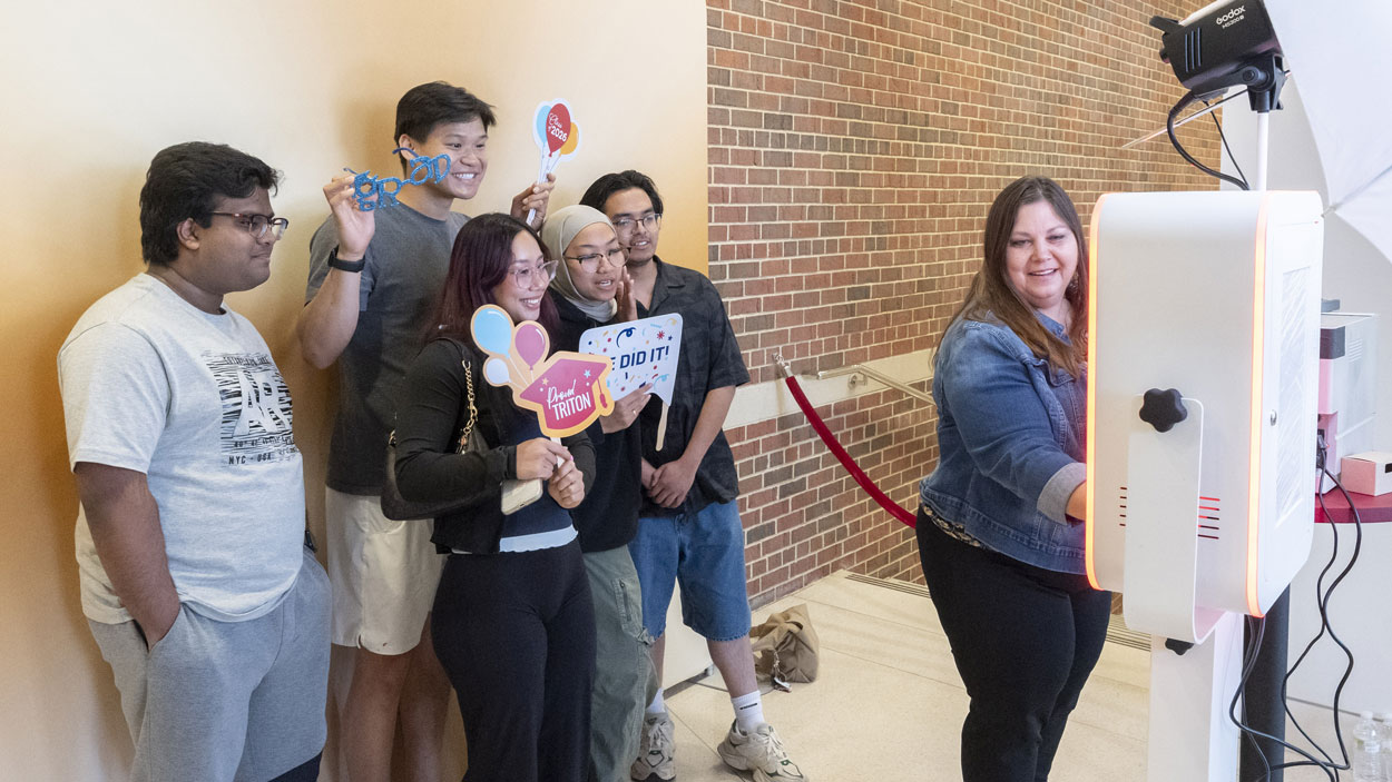 A group of graduating students stand together in the photo booth at the 2026 Triton Toast event