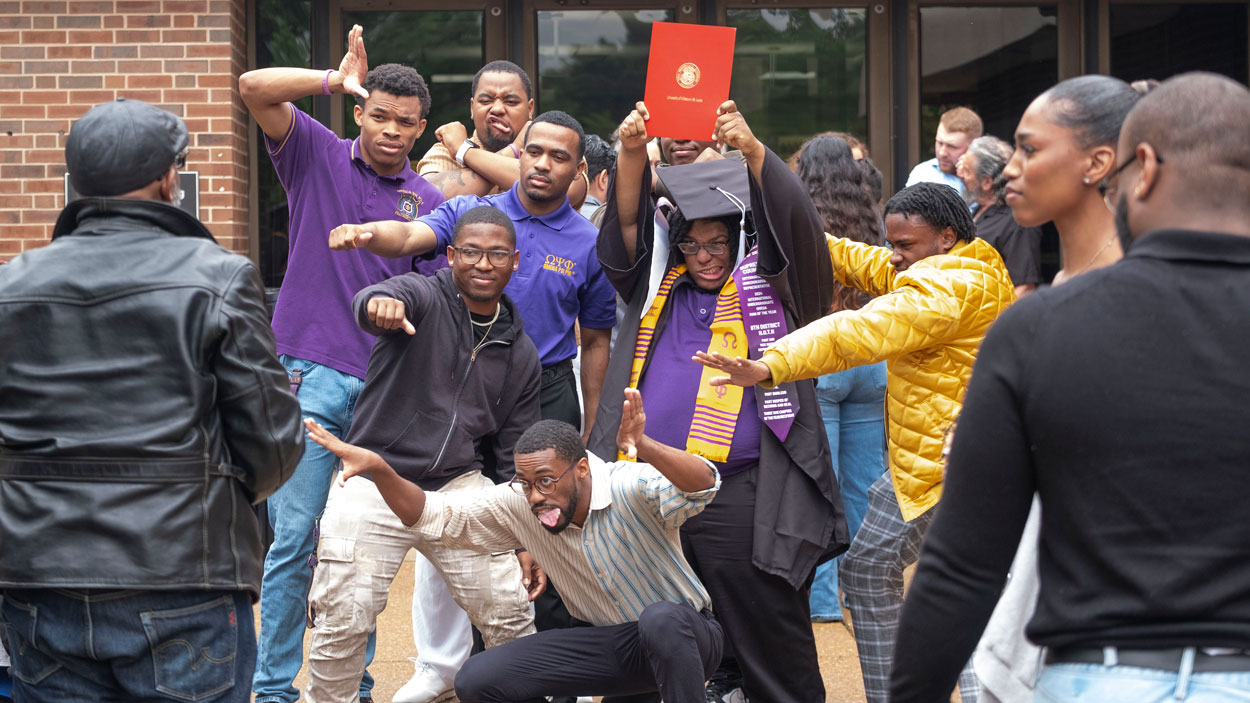 Brandon Dickson, a computer science graduate, celebrates with friends after commencement.