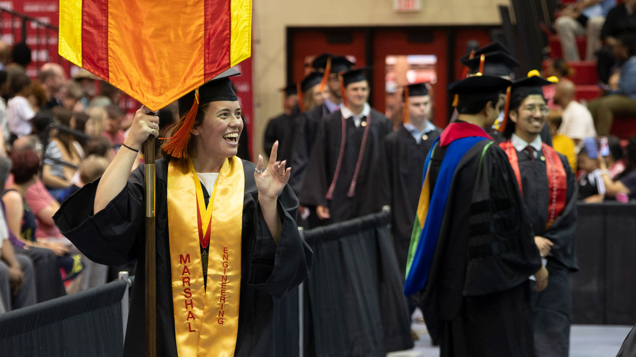 Alexandra Lane, a student marshal for the UMSL/Washington University Joint Engineering Program and mechanical engineering graduate, carries the banner during commencement on May 15.