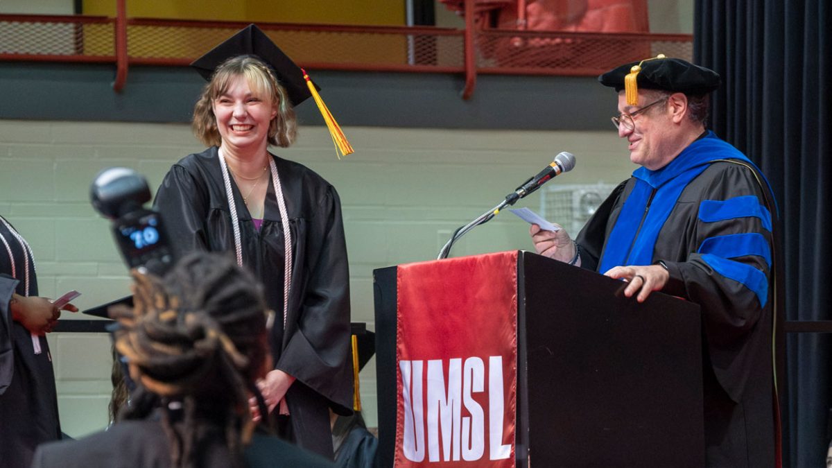 Music graduate Kirsten Dolejsi smiles as Jim Henry, associate professor of music, announces her name during commencement.
