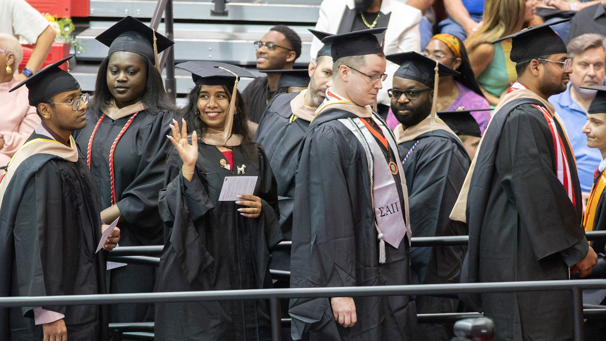 Pavani Maheswarapu, a December graduate with a master’s degree in Information Systems and Technology, waves to family and friends during commencement.