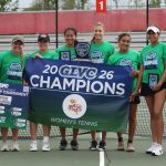 Members of the UMSL women's tennis team hold up a banner and trophy after winning the Great Lakes Valley Conference Championship for the first time in school history.