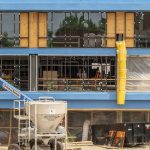 Construction workers install glass on the new Social Sciences and Business Building modernization and expansion project in the Quad on North Campus at the University of Missouri–St. Louis.
