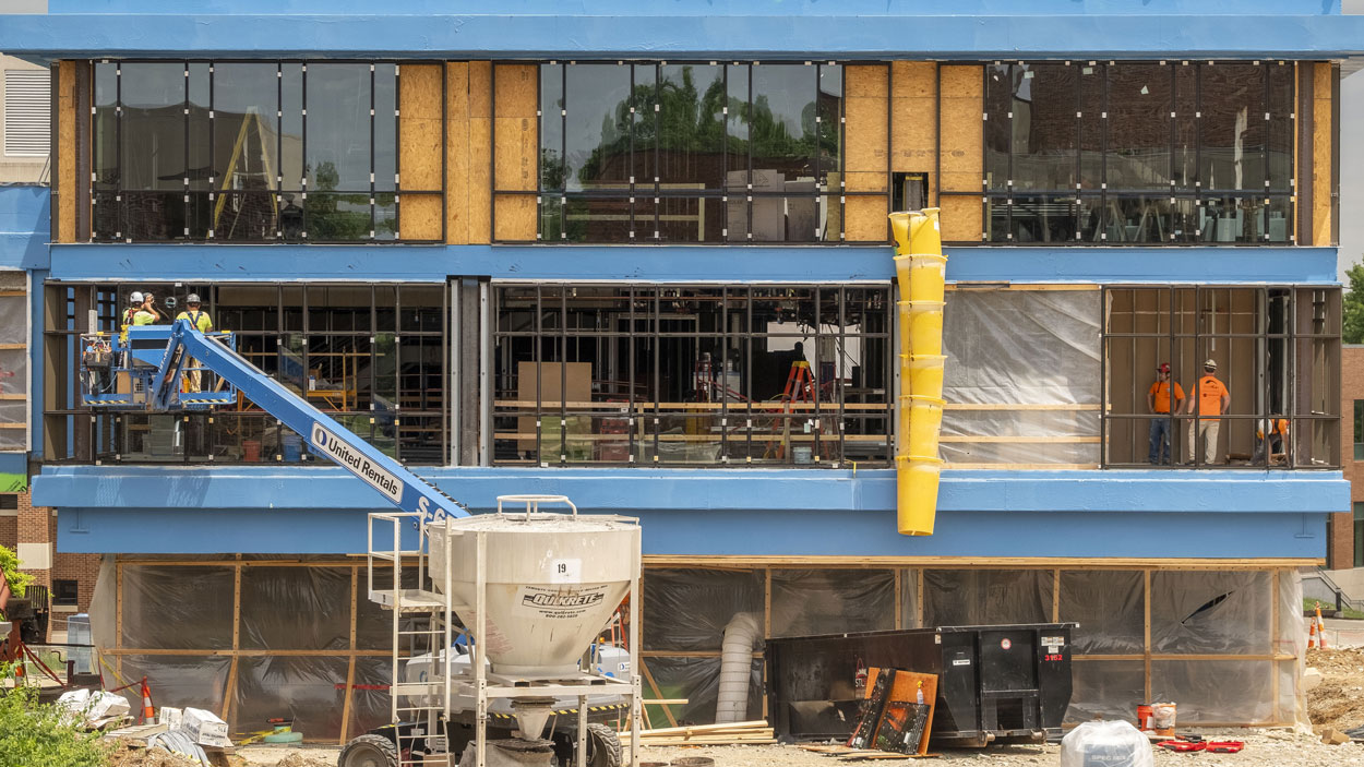 Construction workers install glass on the new Social Sciences and Business Building modernization and expansion project in the Quad on North Campus at the University of Missouri–St. Louis.