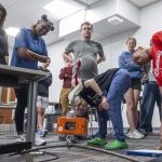 Students in the "Elementary Engineering Design" course at the University of Missouri–St. Louis School of Engineering watch as their S-Hook design is tested by holding a heavy load off the floor during a class on May 8.