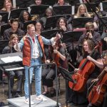 Musicians at the University of Missouri–St. Louis chuckle as Assistant Teaching Professor David Wacyk takes the stage dressed up as Marty McFly, Michael J. Fox's famous character from the classic 1985 movie "Back to the Future," to conduct the UMSL Symphony Orchestra and Wind Ensemble's end-of-semester concert, "UMSL at the Movies," on May 13 in the Blanche M. Touhill Performing Arts Center.