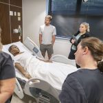 UMSL students gather around a mannequin in the College of Nursing's Learning Resource and Simulation Center.