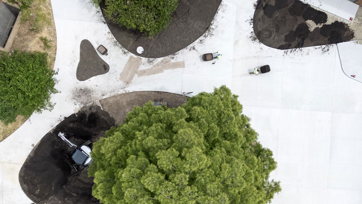 Crew members spread mulch in the courtyard outside the Richter Family Welcome and Alumni Center last Thursday as they worked to get the grounds ready for the official opening of the 31,000-square-foot building next month.
