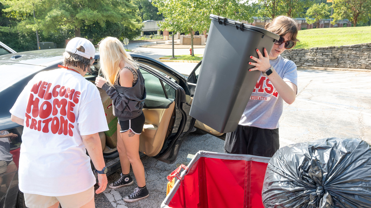Allison Baltz helps load a roller cart