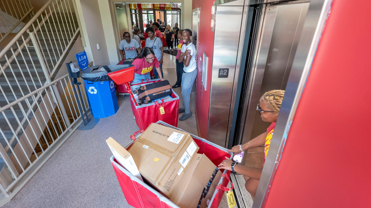 Volunteers move roller carts into elevator