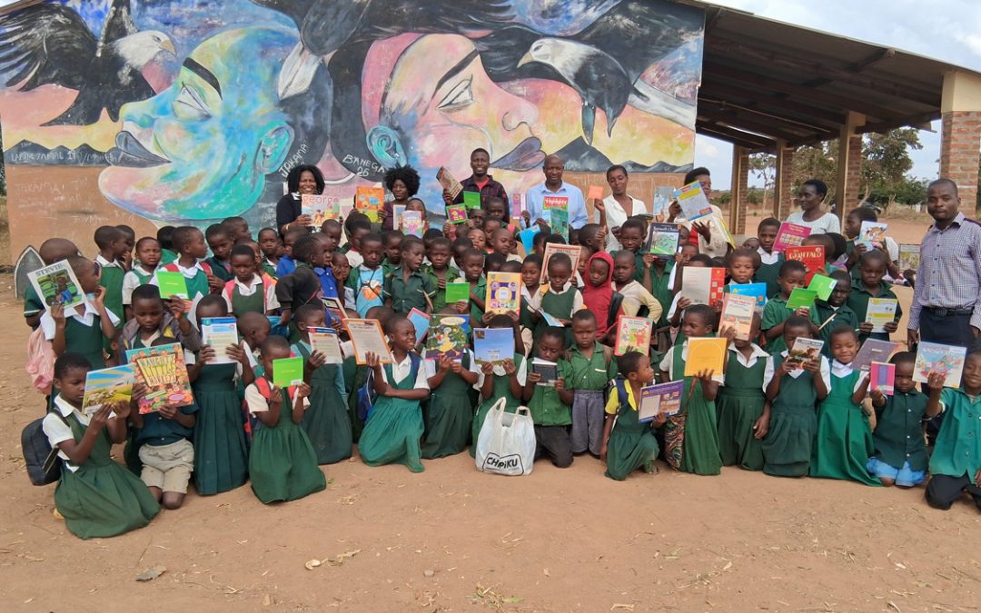Social Work Senior Academic Advisor Tchule Moore delivers books to school children in Malawi