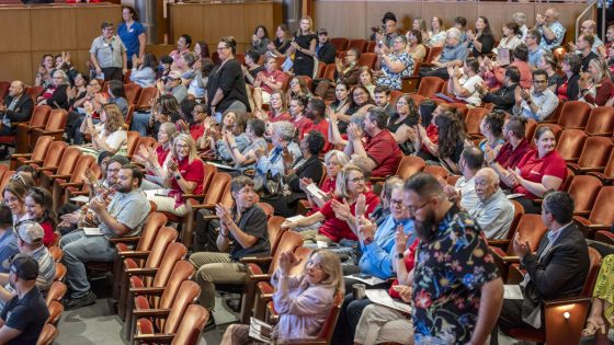 Attendees of the State of the University Address applaud fellow faculty and staff members who've been promoted in the past year.
