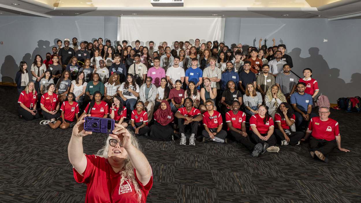 Jessica Hylton takes a selfie with UMSL's newest international students at Global Triton Welcome