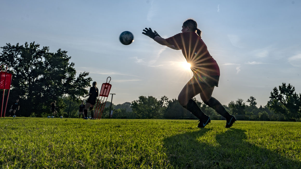 Goalkeeper Hannah McFarlane prepares to stop a shot during the women's soccer team's early morning workout last Tuesday