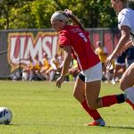 UMSL women's soccer player Josie Maddox dribbles while being hounded by an Illinois Springfield defender