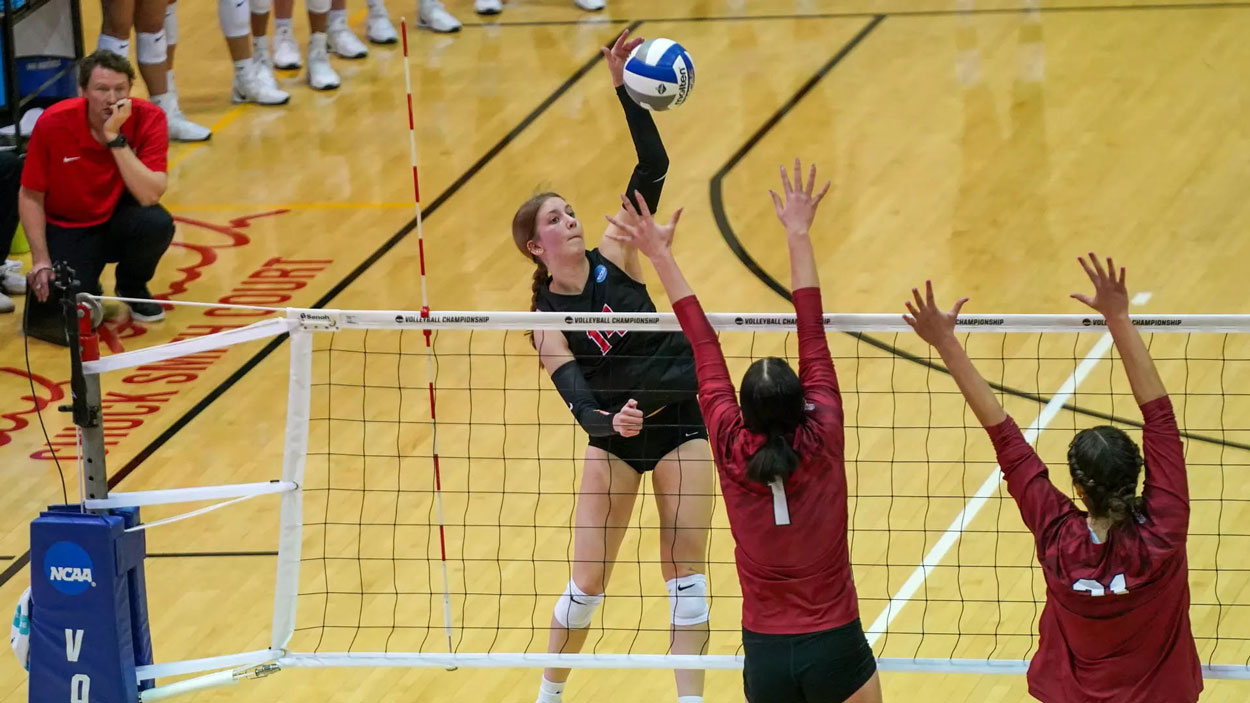 Alayna Santel hits over a pair of blockers