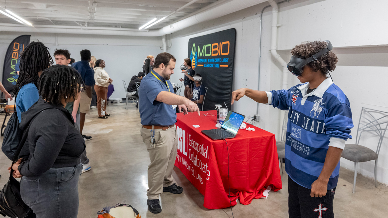 Zachary Ridings, UMSL Advanced Geospatial Lab Manager, works with students on on to use virtual reality goggles