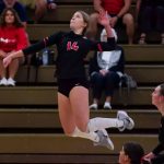 Alayna Santel jumping to spike a volleyball