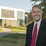 Alum Joe Blanner standing outside the Richter Family Welcome and Alumni Center