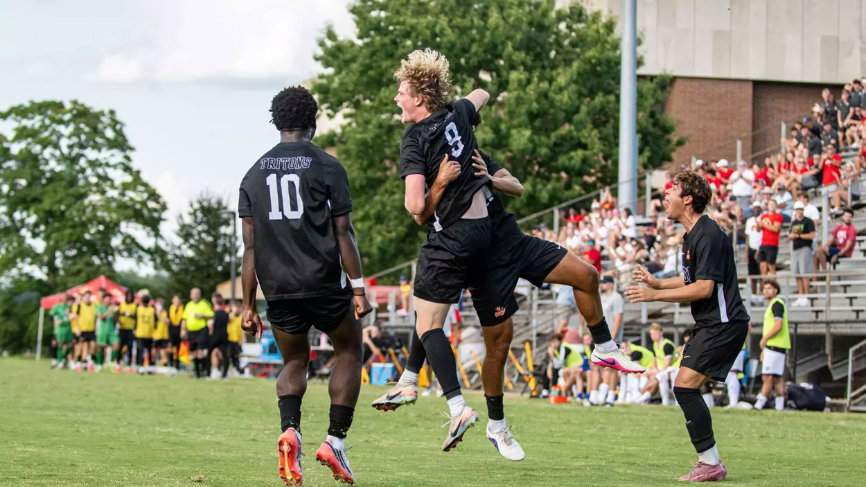 UMSL men's soccer player Brady Freeman celebrates with teammates after scoring a goal