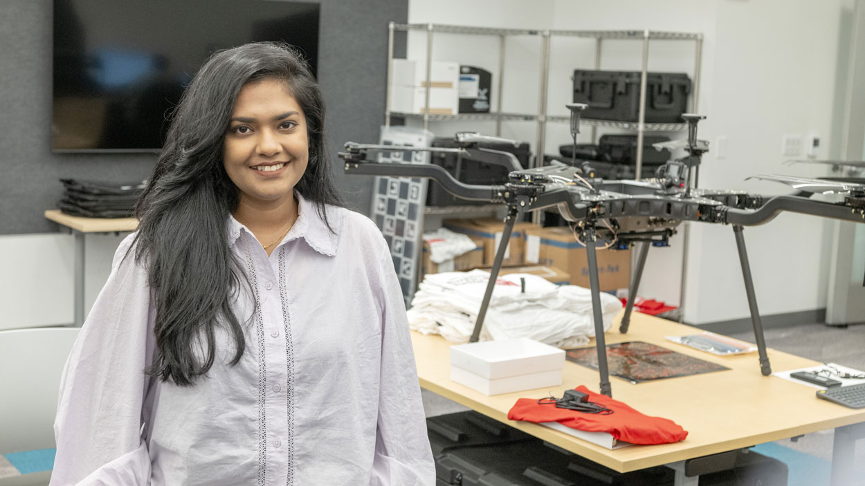 Supria Sarkar stands near a drone in the Geospatial Advanced Technology Lab