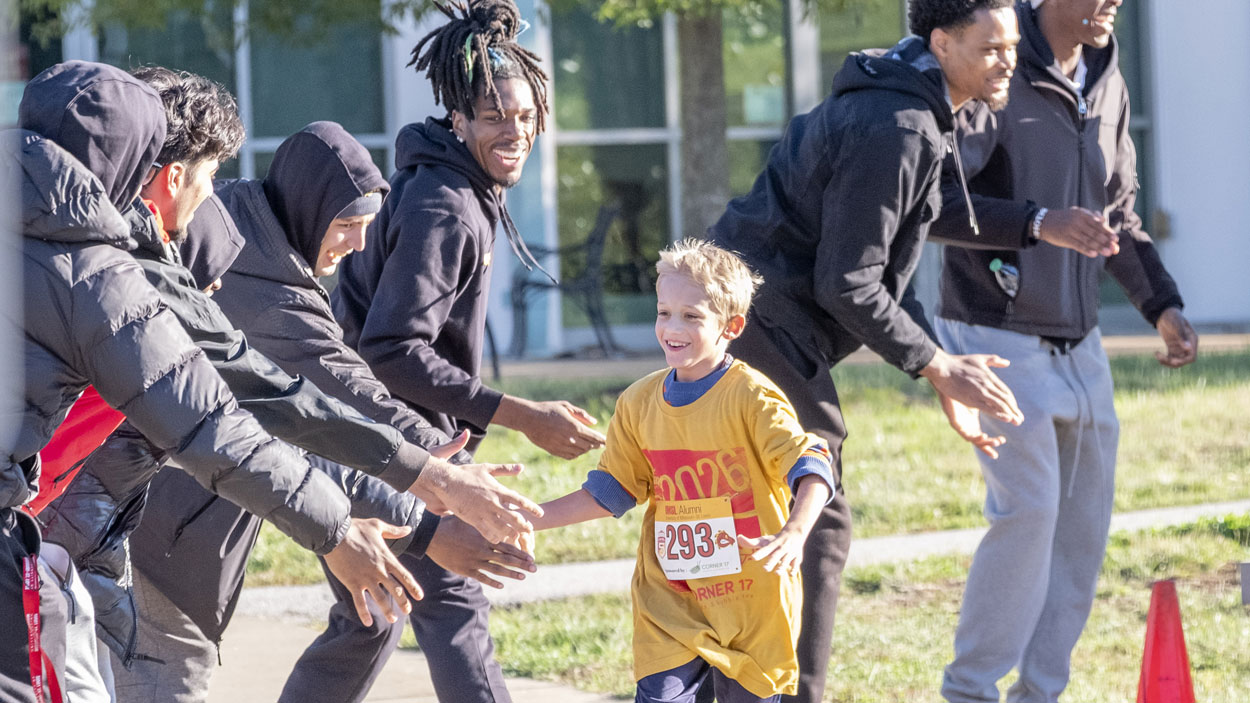 Carter Campbell gets high-fives from members of the UMSL men's basketball team